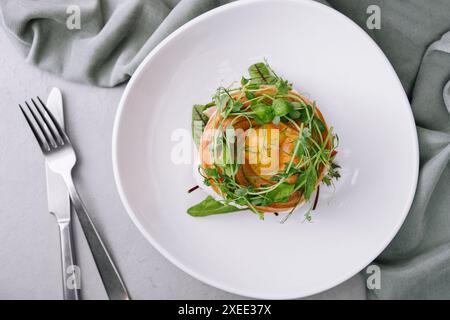 Bagel au saumon salé, épinards, avocat et oeuf dur mou au jaune liquide Banque D'Images