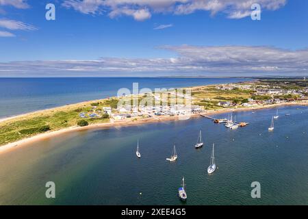 Findhorn Beach et Bay Moray Firth Scotland en été ensoleillé et un ciel bleu au-dessus des yachts amarrés du village et une mer bleu vert Banque D'Images