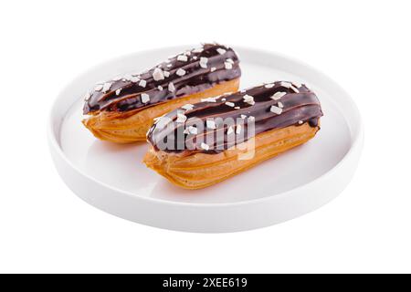 Deux eclairs avec glaçage au chocolat dans une assiette blanche Banque D'Images