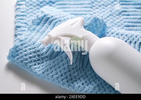 Produit de nettoyage avec un pulvérisateur sur un fond d'un chiffon en microfibre bleu. Banque D'Images