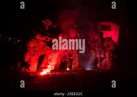 Un groupe de soldats en uniforme de camouflage tient des armes avec des missions de patrouille la nuit Banque D'Images