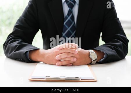 Gros plan des mains d'un homme d'affaires sur un contrat, prêt pour un accord formel. Banque D'Images