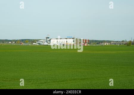 Stanionu kaimas, Lituanie - 2 mai 2023 : un petit bâtiment aéroportuaire avec quelques avions stationnés devant. Il y a un champ vert dans le premier groupe Banque D'Images