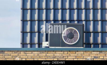 Unité de pompe à chaleur à source d'air installée à l'extérieur dans une maison moderne avec des briques aux pays-Bas Banque D'Images