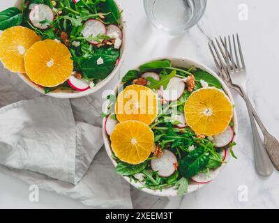 Bol à salade avec oranges, épinards, arugula, radis Banque D'Images