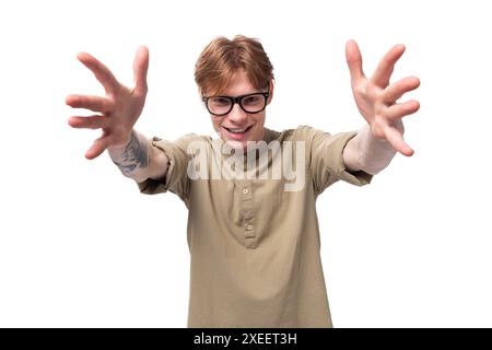 Jeune homme européen aux cheveux roux aimant vêtu d'une chemise brun clair avec un tatouage Banque D'Images