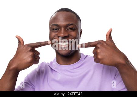 Portrait en gros plan d'un jeune fier homme américain vêtu d'un t-shirt lilas clair sur un fond blanc avec espace copie Banque D'Images