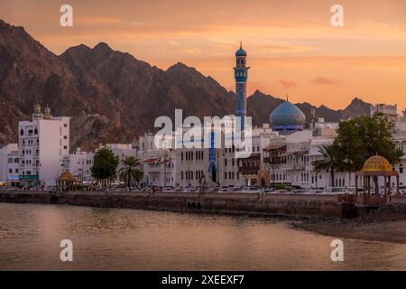 Le magnifique panorama de Mutrah Corniche à Mascate, la capitale d'Oman, avec la mosquée Masjid Al Rasool Al A'dham, les gens sur la promenade, au coucher du soleil. Banque D'Images