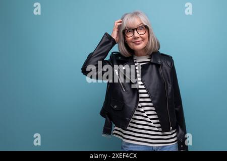 Informelle fraîche et saine femme d'âge moyen à cheveux gris grand-mère dans une veste rocker sur un fond lumineux avec espace de copie Banque D'Images