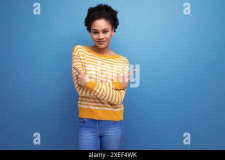 Afro brunette 20s latin jeune femme avec queue de cheval en tenue décontractée sur fond isolé Banque D'Images
