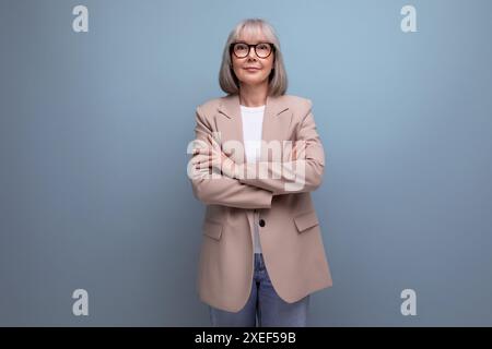 Preppy Fresh 60s femme d'affaires d'âge moyen dans un look élégant sur fond de studio lumineux avec espace de copie Banque D'Images