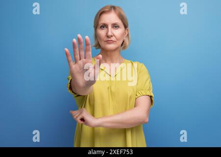Douteuse femme d'âge moyen blonde montrant un geste de désaccord Banque D'Images