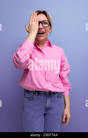 Jeune femme d'affaires blonde élégante surprise habillée en fond isolé de chemise rose Banque D'Images