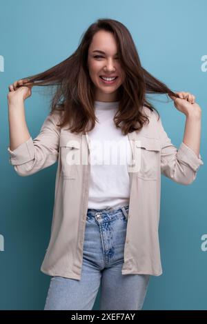 Positive joyeuse jeune brune femelle adulte en chemise décontractée Banque D'Images