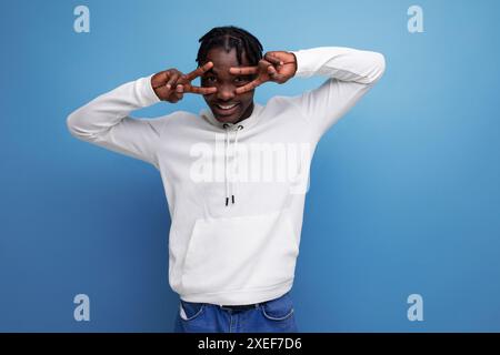 Modèle jeune homme brune européen à la peau foncée dans un sweat à capuche blanc Banque D'Images
