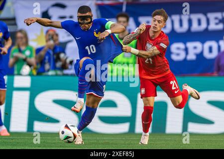 Kylian Mbappe (à gauche), de France, et Nicola Zalewski (à droite), de Pologne, sont en action lors du match de la phase de groupes de l’UEFA EURO 2024 opposant la France et la Pologne Banque D'Images