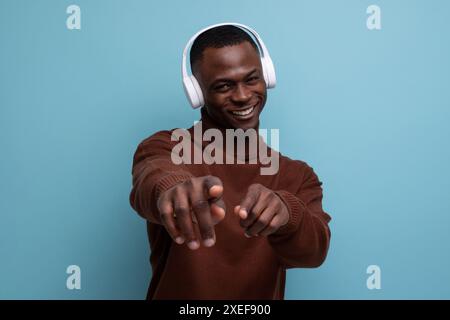 Jeune américain de 25 ans avec un casque sans fil blanc de grande taille devant l'espace de copie Banque D'Images