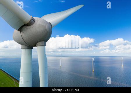 Une seule éolienne debout au milieu d'une grande masse d'eau, exploitant l'énergie du vent pour produire de l'électricité Banque D'Images