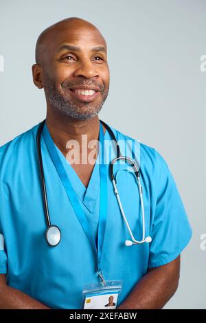 Gros plan Portrait de studio d'un médecin mature souriant portant des gommages sur fond blanc Banque D'Images
