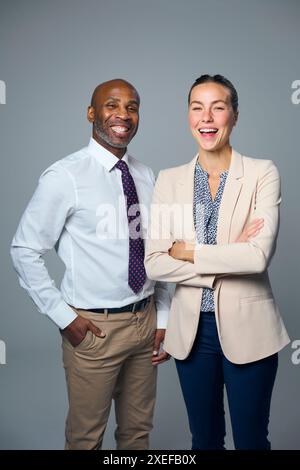 Studio Portrait d'homme d'affaires souriant et femme d'affaires portant des costumes sur fond blanc Banque D'Images