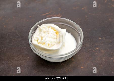 Fromage stracciatella dans un bol en verre sur la table, mise au point sélective Banque D'Images