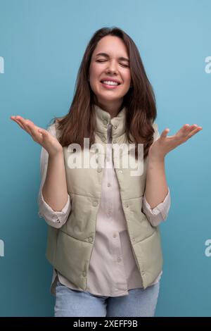 Jeune femme brune positive émotionnelle dans un style décontracté Banque D'Images