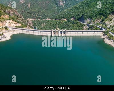 Vue aérienne d'un barrage hydroélectrique générant de l'énergie renouvelable, entouré d'une forêt verdoyante Banque D'Images