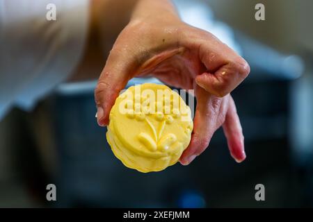 Le beurre alpin jaune doré est découpé en portions à l'aide d'un moule traditionnel en bois. Production de beurre dans la fromagerie appartenant au Filzmoosalm. Promegg, Großarl, Salzbourg, Autriche Banque D'Images