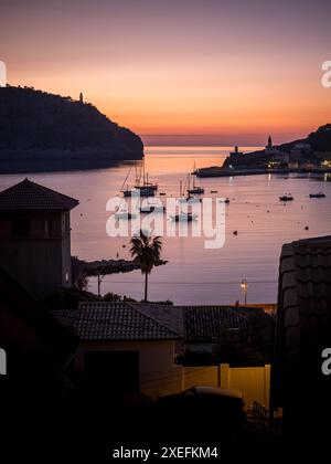 Portrait de l'entrée du port de Port de Sóller avec voiliers ancrés au coucher du soleil, mettant en valeur des teintes chaudes et la mer tranquille, idéal pour les campagnes de voyage. Banque D'Images