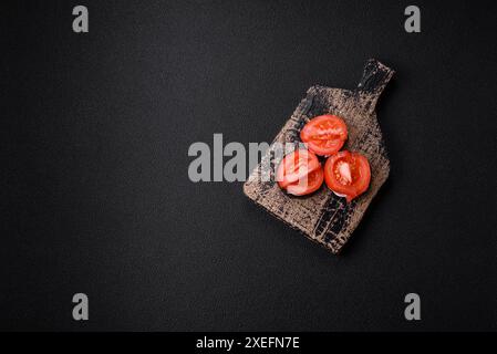 Délicieuse aubergine coupée en cercles grillée et cuite avec de la mayonnaise et des tomates sur un fond de béton foncé Banque D'Images