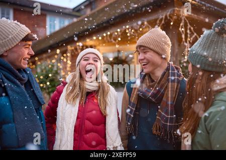 Groupe de filles et garçons adolescents souriants en plein air habillés pour l'hiver dans la neige Banque D'Images