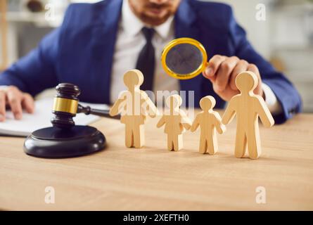Juge examinant les figures en bois d'Une famille au tribunal Banque D'Images