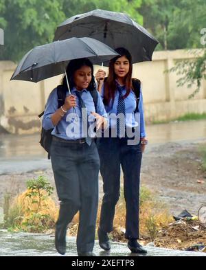 GHAZIABAD, INDE - JUIN 27 : garçons et filles allant sous la pluie avec des parapluies près de National Highway IMS College, le 27 juin 2024 à Ghaziabad, Inde. Le Département météorologique indien (IMD) a prédit l'arrivée de la mousson sur de grandes parties du nord-ouest de l'Inde au cours des trois à quatre prochains jours, mais n'a pas précisé de date pour Delhi. La région devrait recevoir des pluies de mousson vers juin 30. (Photo Sakib Ali/Hindustan Times/Sipa USA ) Banque D'Images