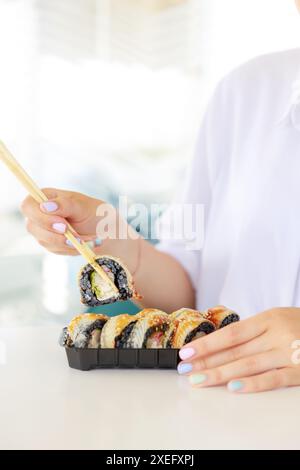 Sushi roll Philadelphia avec le saumon, l'anguille fumée, avocat, fromage à la crème sur fond noir. Menu Sushi. La nourriture japonaise. Banque D'Images