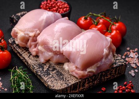 Filets de cuisse de poulet frais crus avec sel, épices et herbes Banque D'Images