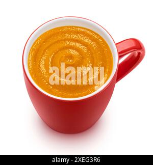 Soupe à la crème de citrouille instantanée dans une tasse rouge isolée sur fond blanc, vue de dessus Banque D'Images