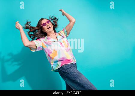 Portrait photo de la danse de lunettes de soleil de femme senior attrayante amusez-vous habillé élégamment vêtements colorés isolés sur fond de couleur cyan Banque D'Images