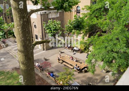 Londres, Royaume-Uni, 27 juin 2024. Météo britannique : Londres Soho cour pack de cour de l'église avec des chercheurs de soleil dans l'après-midi d'été alors que les vagues de chaleur s'éteignent, avec de violents coups de vent et de fortes pluies sur son chemin pour frapper une partie du Royaume-Uni. Crédit : Xiu Bao/Alamy Live News Banque D'Images