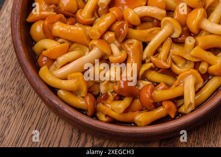 Délicieux champignons au miel marinés avec du sel et des épices dans une assiette en céramique Banque D'Images