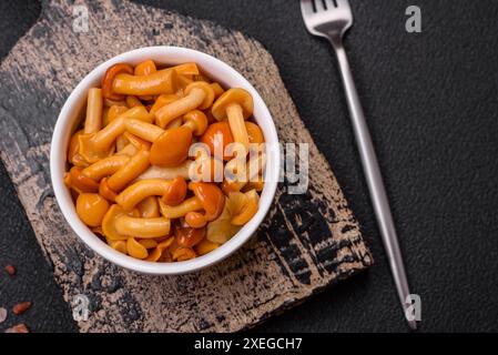 Délicieux champignons au miel marinés avec du sel et des épices dans une assiette en céramique Banque D'Images