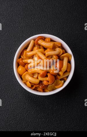 Délicieux champignons au miel marinés avec du sel et des épices dans une assiette en céramique Banque D'Images