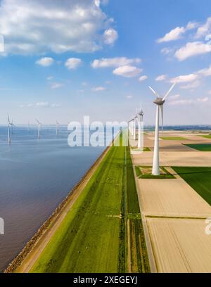 Une vue aérienne fascinante d'une rangée de majestueuses éoliennes tournant gracieusement dans le vaste paysage de Flevoland, aux pays-Bas Banque D'Images