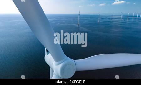 Une perspective aérienne fascinante met en valeur le vaste parc éolien dans les eaux néerlandaises de Flevoland, où l'élégant moulin à vent turb Banque D'Images