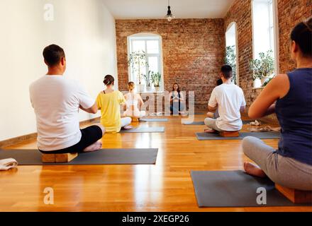 Groupe de jeunes sportifs attirants personnes pratiquant la leçon de yoga avec instructeur Banque D'Images