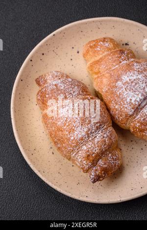 Délicieux croissants croustillants sucrés frais avec de la crème au chocolat sur une assiette en céramique Banque D'Images