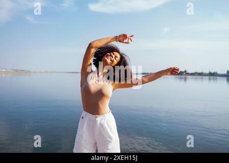 Gros plan portrait d'une adolescente afro-américaine heureuse souriant avec douceur à l'appareil photo Banque D'Images