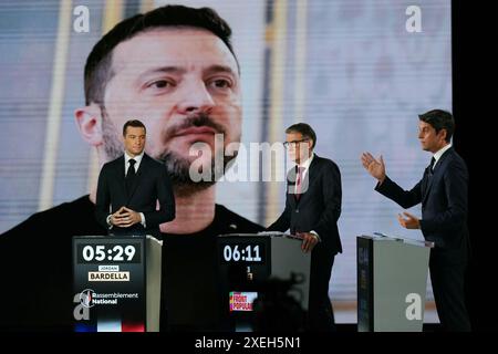 Premier secrétaire du Parti socialiste de gauche (PS) et député Olivier Faure (C), Jordan Bardella (G), président du parti d’extrême droite rassemblement National (RN) et eurodéputé principal français, et Gabriel Attal, premier ministre français, se tiennent devant un écran montrant une photo du président ukrainien Volodymyr Zelensky alors qu’ils participent à un débat politique diffusé sur la chaîne de télévision française France 2 à Paris le 27 juin 2024, à la veille des élections anticipées en France pour une nouvelle Assemblée nationale. Photo Dimitar Dilkoff/Pool/ABACAPRESS. COM Banque D'Images