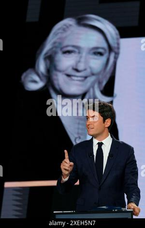Le premier ministre français Gabriel Attal s’exprime devant un écran montrant une photo du chef du groupe parlementaire d’extrême droite rassemblement National (RN) à l’Assemblée nationale Marine le Pen lors d’un débat politique avec le premier secrétaire du Parti socialiste de gauche (PS) et député Olivier Faure et le président du parti d'extrême droite rassemblement National (RN) et eurodéputé principal Jordan Bardella ont diffusé sur la chaîne de télévision française France 2 à Paris le 27 juin 2024, à l'approche des élections anticipées en France pour une nouvelle Assemblée nationale. Photo Dimitar Dilkoff/Pool/ABACAPRESS. COM Banque D'Images