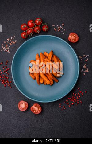 Délicieuses frites de patates douces croustillantes avec sel, épices et herbes Banque D'Images