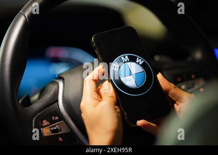 Hong Kong, Chine. 26 juin 2024. Une photographie montre un logo de BMW sur un smartphone avec le volant en arrière-plan. (Photo de Serene Lee/SOPA images/SIPA USA) crédit : SIPA USA/Alamy Live News Banque D'Images